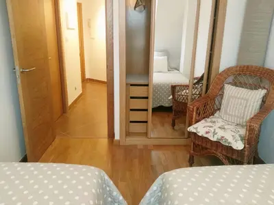 a room with a mirror and a bed and a chair at San Ciprian Atico Tres Playas by I Love Norte in San Ciprián