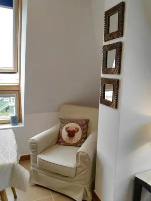 a living room with a chair and a wall at San Ciprian Atico Tres Playas by I Love Norte in San Ciprián