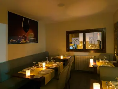a restaurant with tables with candles and a window at Hotel Rural Las Montañas de Pumar in Besullo