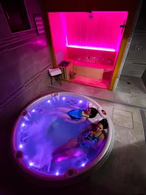 two people in a hot tub with purple lights at Hotel Rural Las Montañas de Pumar in Besullo