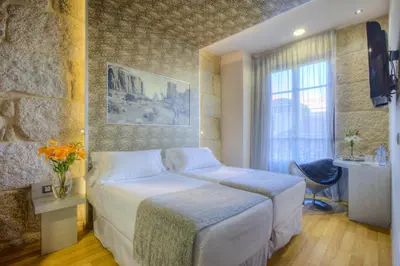 a hotel room with a bed and a window at NH Ourense in Ourense