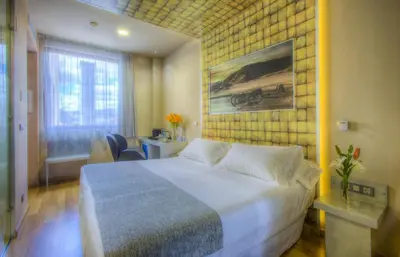 a hotel room with a large bed and a window at NH Ourense in Ourense