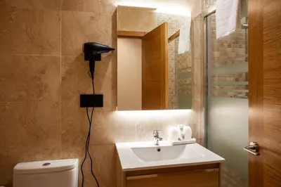 a bathroom with a sink and a mirror and a toilet at Plaza Obradoiro Express by Bossh! Hotels in Santiago de Compostela