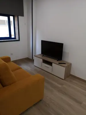 a living room with a couch and a flat screen tv at Monqar Playa Foz in Foz