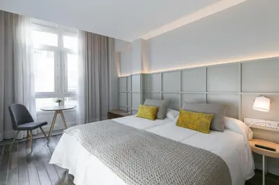 a bedroom with a large bed with yellow pillows at Hotel Pousada Real in Caldas de Reis