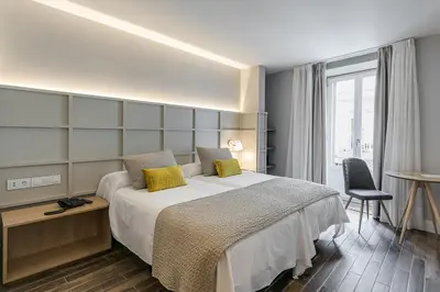 a bedroom with a bed and a desk and a window at Hotel Pousada Real in Caldas de Reis