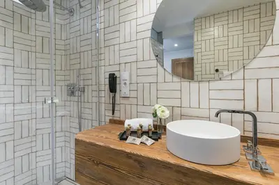 a bathroom with a tub and a mirror at Hotel Pousada Real in Caldas de Reis