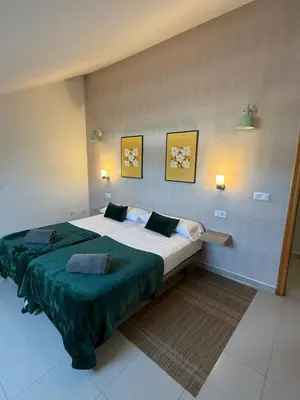 a bedroom with a large bed with a green blanket at Casa Grande do Costureiro-Para Grupos en Portomarín con Terraza y Vistas in Portomarin