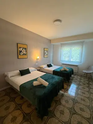 a bedroom with two beds and a window at Casa Grande do Costureiro-Para Grupos en Portomarín con Terraza y Vistas in Portomarin