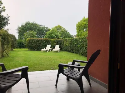 two chairs sitting on a porch with a yard at Apartamentos El Guindal in Tapia de Casariego