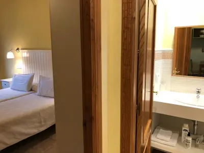 a bedroom with a bed and a sink and a mirror at Apartamentos El Guindal in Tapia de Casariego