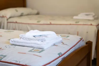 a pile of towels sitting on top of a bed at Hostal Sequeiros in San Ciprián de Viñas