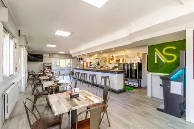 a restaurant with tables and chairs and a bar at Hostal Sequeiros in San Ciprián de Viñas