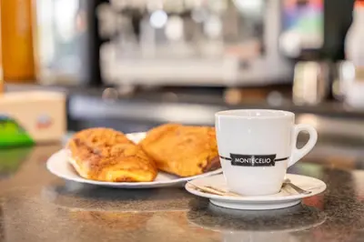 a cup of coffee and two pastries on a table at Hostal Sequeiros in San Ciprián de Viñas