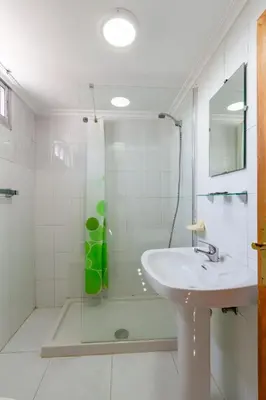 a white bathroom with a sink and a shower at Hostal Sequeiros in San Ciprián de Viñas