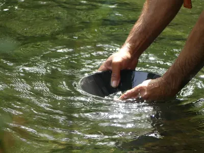 a person is holding a bowl in the water at Casa Turismo Rural O FILANDÓN in Suertes