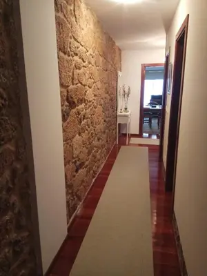 a hallway with a stone wall and a carpet at apartment garden in Caldas de Reis