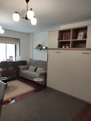 a living room with a couch and a large white refrigerator at apartment garden in Caldas de Reis