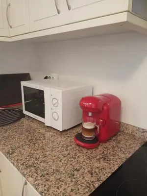 a coffee maker sitting on a counter next to a microwave at apartment garden in Caldas de Reis