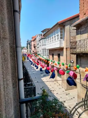 a row of colorful umbrellas on a city street at apartment garden in Caldas de Reis