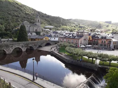 a bridge over a river next to a town at Camino Real in Molinaseca