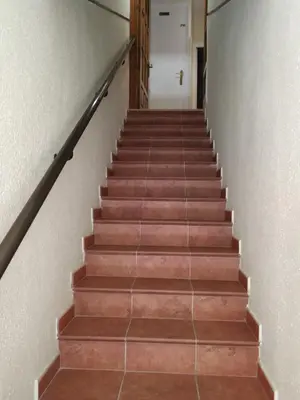 a stairway with brown steps with a white door at Camino Real in Molinaseca