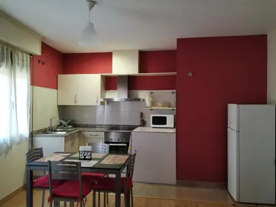a kitchen with red walls and a table and chairs at Camino Real in Molinaseca