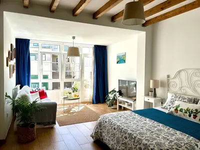 a bedroom with a bed and a window with blue curtains at El Galeón in Ribadeo