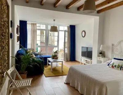 a bedroom with a bed and a living room at El Galeón in Ribadeo
