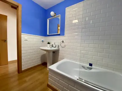a bathroom with a white tub and a sink at El Galeón in Ribadeo