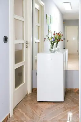 a room with a white refrigerator with a vase of flowers on it at Pension As Burgas Ii in Caldas de Reis
