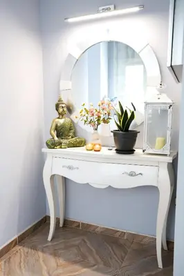 a dressing table with a mirror and flowers on it at Pension As Burgas Ii in Caldas de Reis