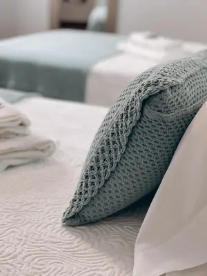 a close up of a bed with a blanket and a knife at Pension As Burgas Ii in Caldas de Reis