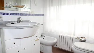 a white bathroom with a sink and a toilet at Hotel Bello in O Pino