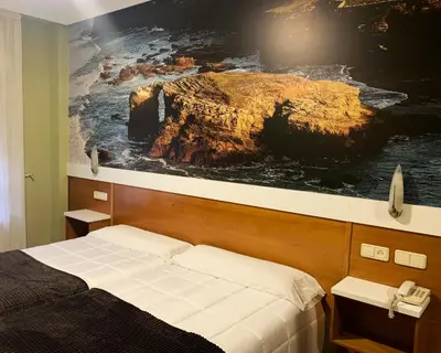 a bedroom with a large painting on the wall at Hotel Bello in O Pino