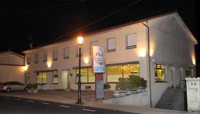 a building with a parking sign in front of it at Hotel Bello in O Pino