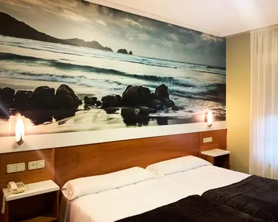 a bedroom with a large painting of the ocean at Hotel Bello in O Pino
