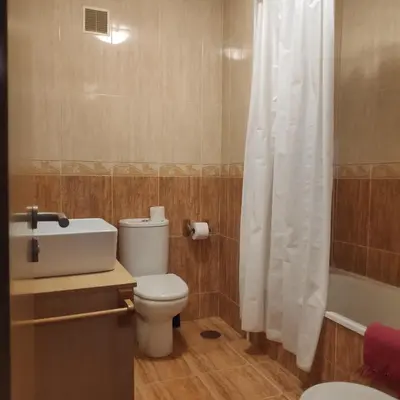 a bathroom with a toilet and a shower curtain at La Mariña in Ribadeo