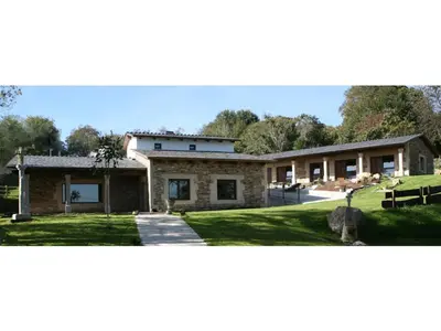a large stone house with a grass yard at Casa Barbadelo in Sarria