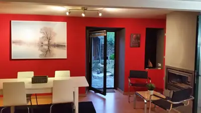 a living room with red walls and a table and chairs at casa cacheiras in Teo