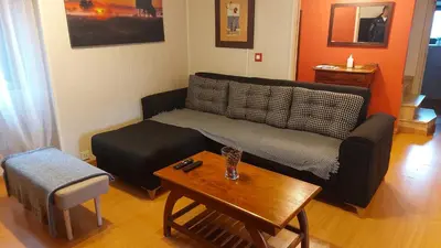 a living room with a black couch and a table at casa cacheiras in Teo