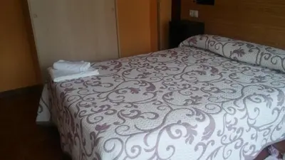 a bed in a hotel room with two towels on it at Hostal-Meson Vilasante in Tríacastela