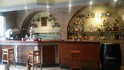 a bar with two arched windows and a brick wall at Hostal-Meson Vilasante in Tríacastela