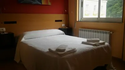 a bedroom with a bed with two towels on it at Hostal-Meson Vilasante in Tríacastela