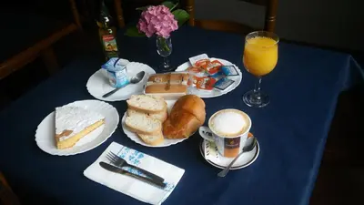 a blue table topped with plates of food and a cup of orange juice at Hostal-Meson Vilasante in Tríacastela