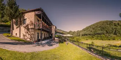 a building with a fence next to a hill at Paraiso del Bierzo in Las Herrerías