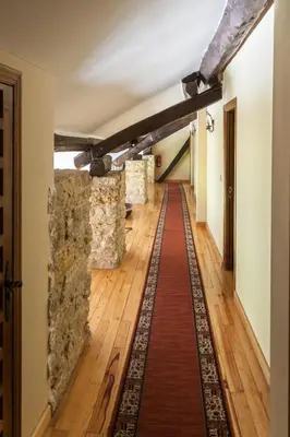 a long hallway with stone walls and a red carpet at Paraiso del Bierzo in Las Herrerías