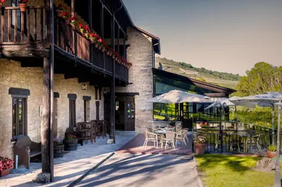 an outdoor patio with tables and chairs and umbrellas at Paraiso del Bierzo in Las Herrerías