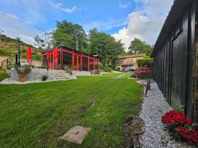 a house with red windows and a green yard at A Pontiga I Casa Rural in Mezonzo