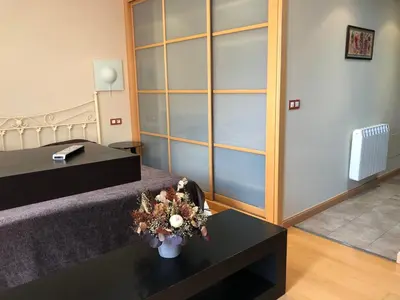 a room with a bed and a table with flowers on it at Apartamentos Albariño in Vegadeo